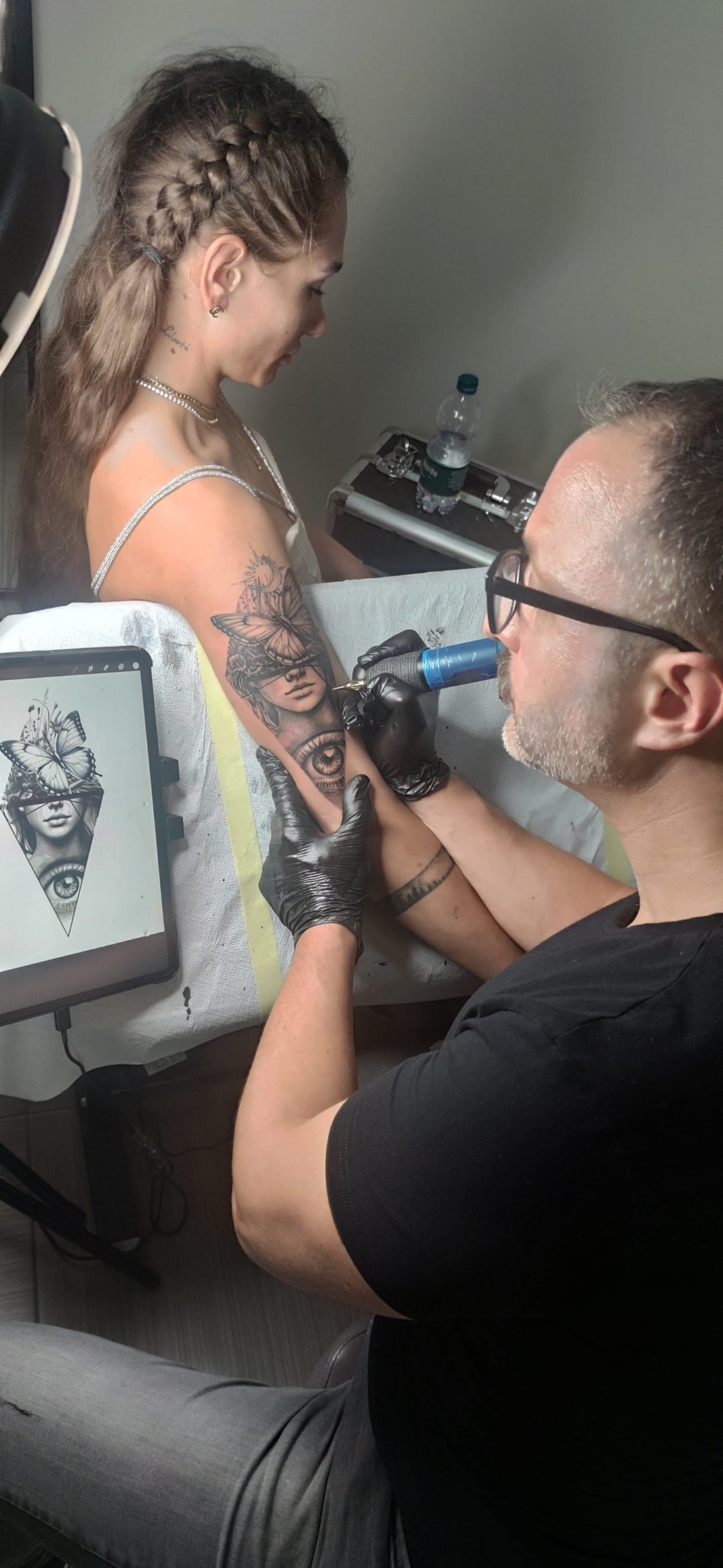 Yatri mentre tatua un ritratto realistico su braccio in studio