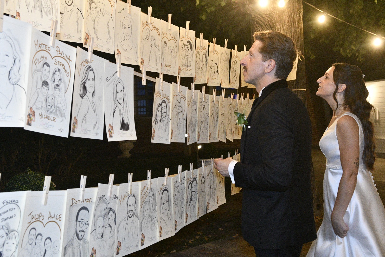 Gli sposi ammirano le caricature appese al muro realizzate da Yatri