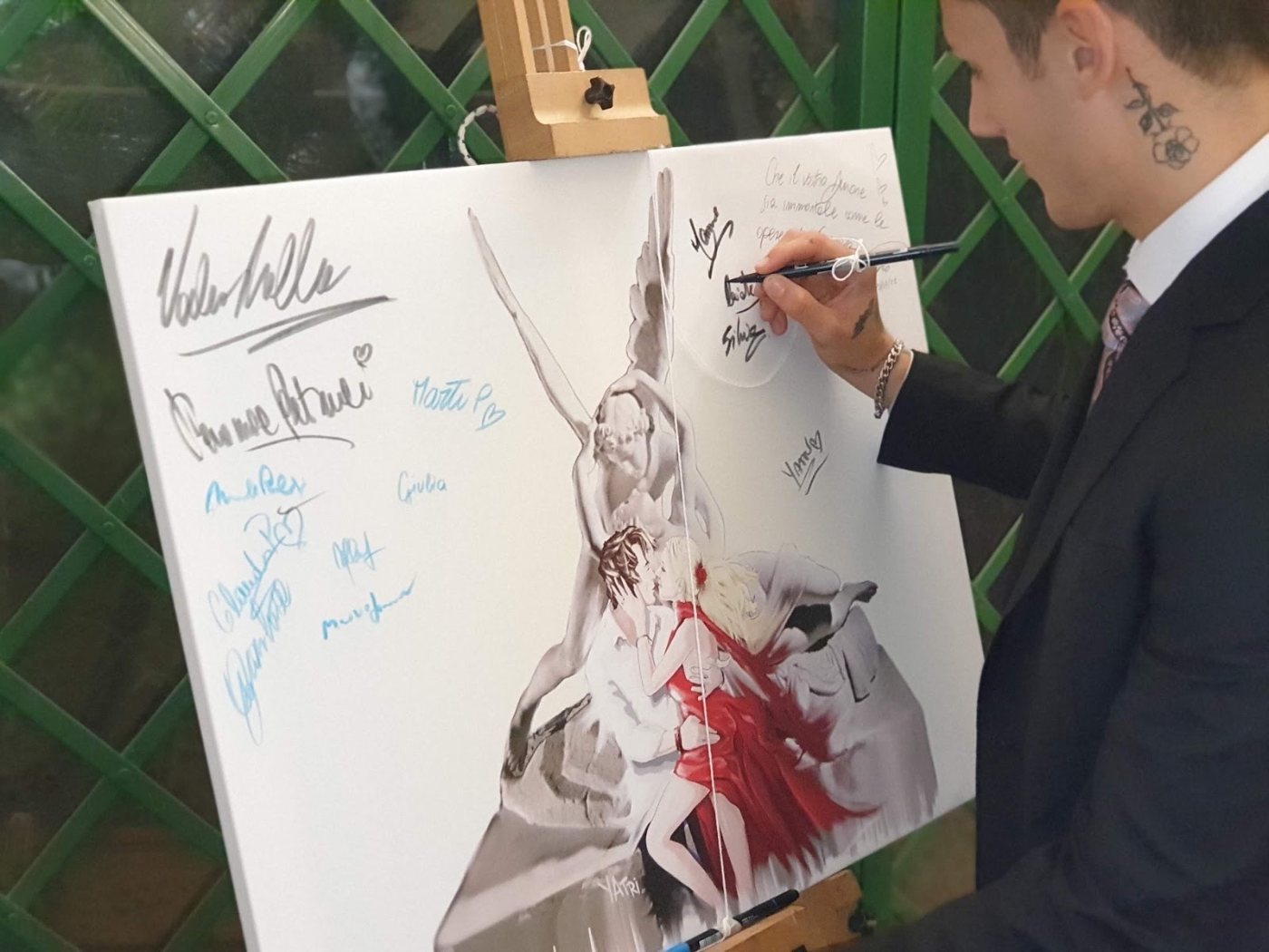 Invitato che firma il quadro tableau con una dedica agli sposi