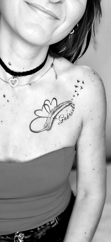 Cuori, piuma e nome — tatuaggio realizzato da Yatri